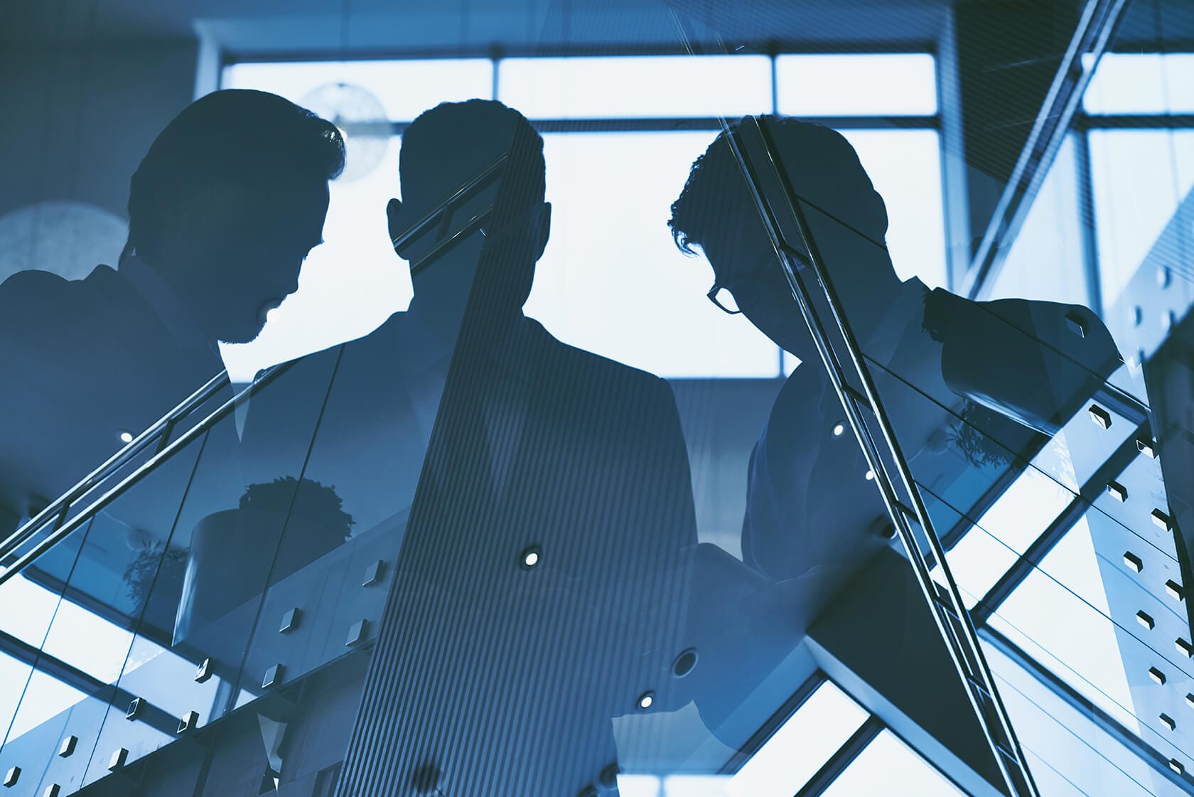 Reflection of three men on building